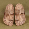 Pair of traditional leather sandals with intricate designs on a textured green background