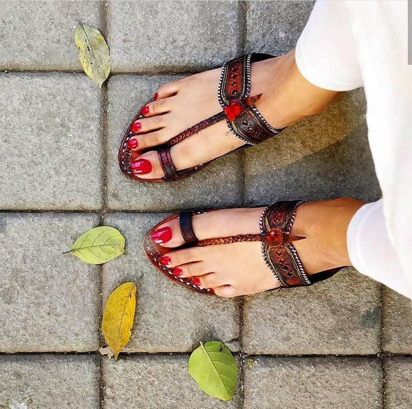 Female foot showcasing original Dola Patta women’s Kolhapuri chappal, artisan-stitched leather traditional sandal fashionable leg perspective.